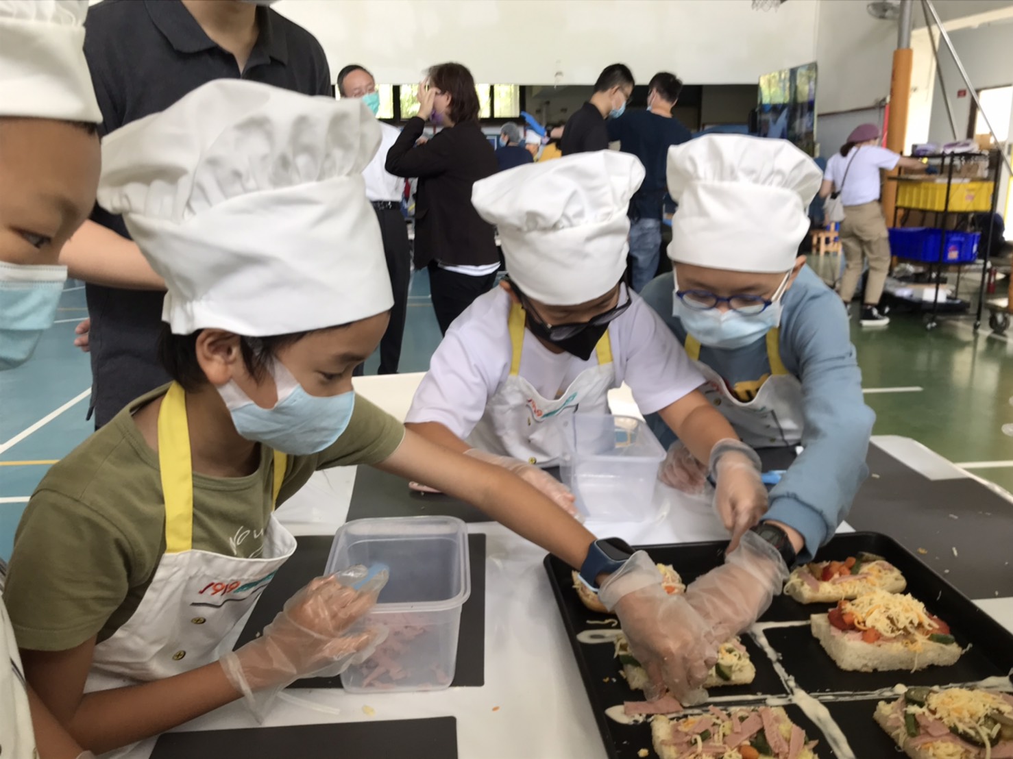 義方國小的孩子在處理完惜食食材後,開始動手放料灑起司,期待成品出爐