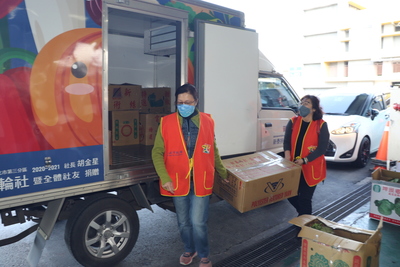 志工將整理好的蔬果搬上惜食車，準備配送至社區共餐據點